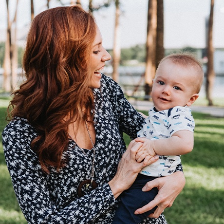 Doctor Maggie smiling and holding her baby