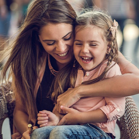 Mother holding her laughing daughter