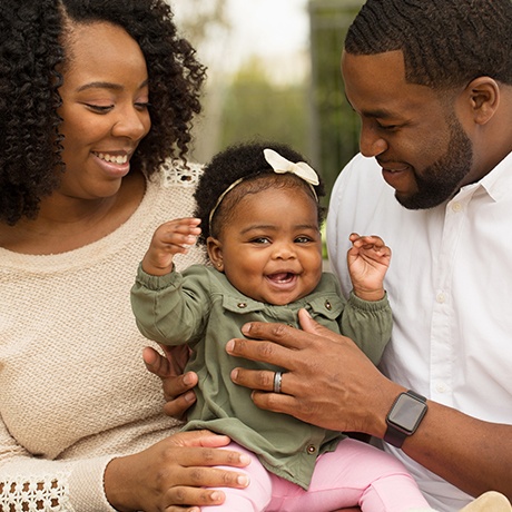 Parents holding laughing baby girl