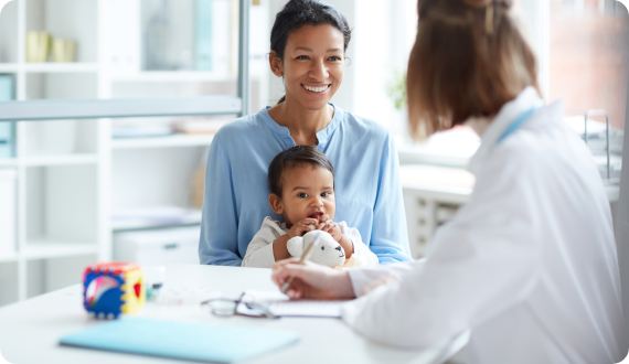 Smiling mother holding child in lap during consultation at Florida Tongue Tie Institute