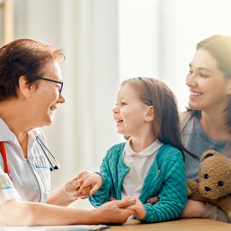 Team member smiling at mother and child