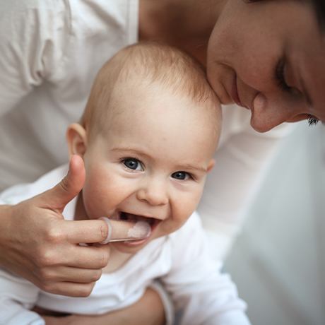 Mother brushing baby's teeth