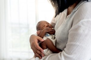 mom holding her infant with a lip or tongue tie