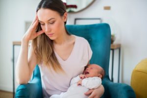 stressed mom with crying baby with colic and tongue tie