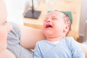 a mom holding her crying baby