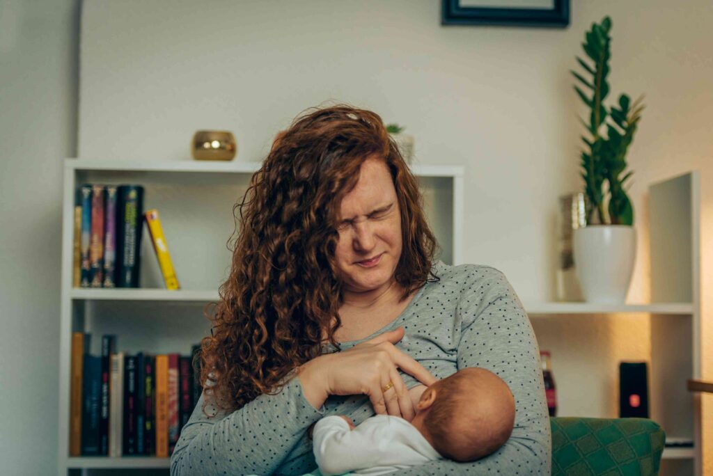 Woman in pain breastfeeding